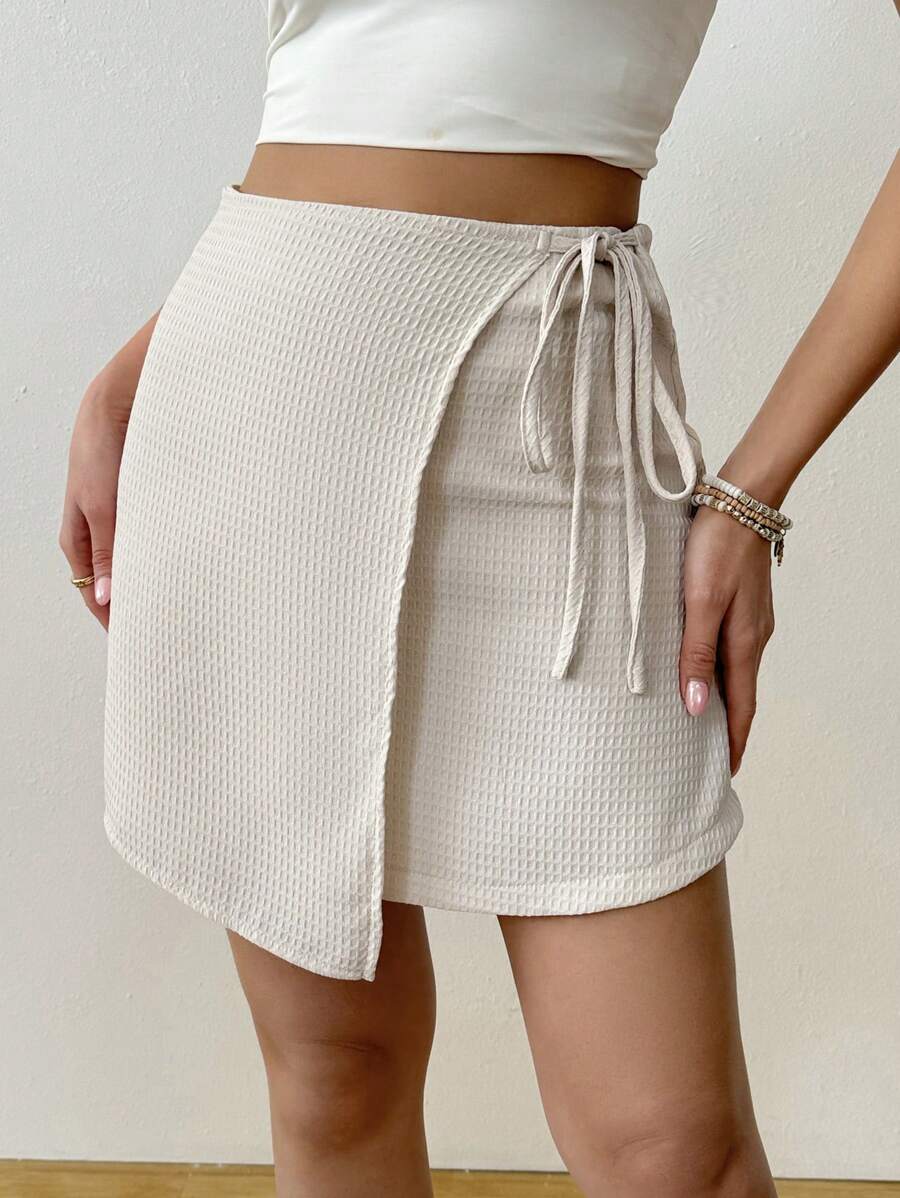Asymmetrical minimalist casual wrap skirt in textured fabric tied