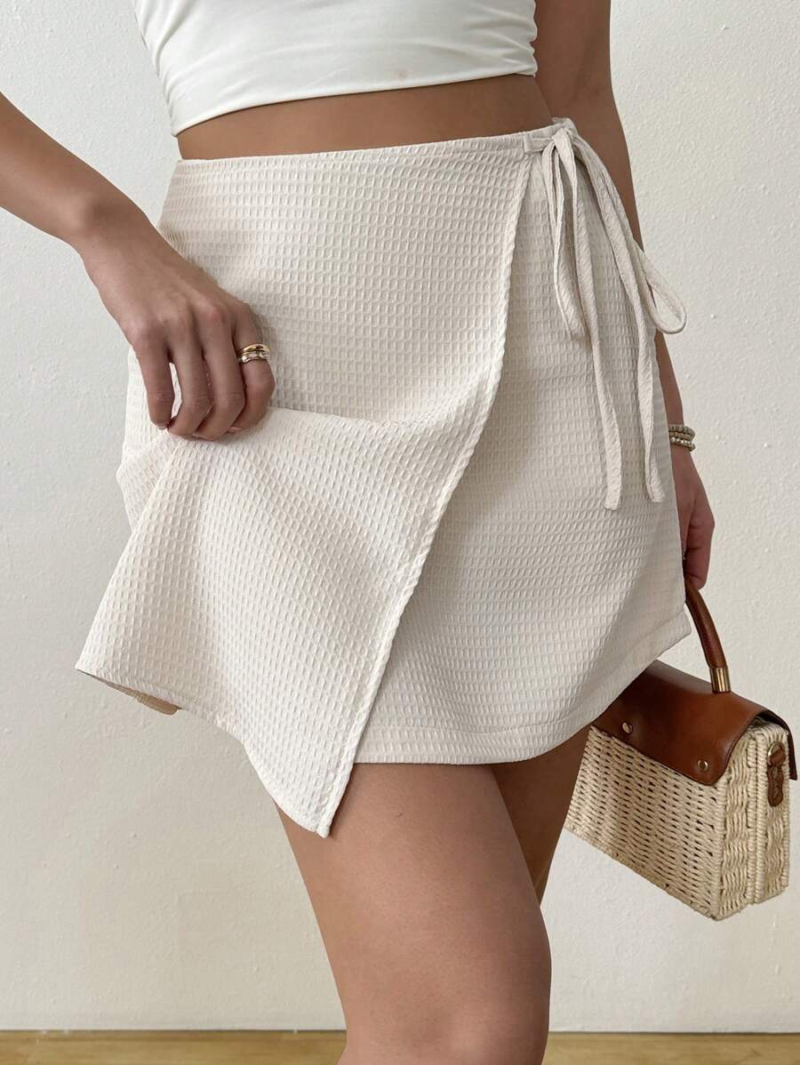 Asymmetrical minimalist casual wrap skirt in textured fabric tied